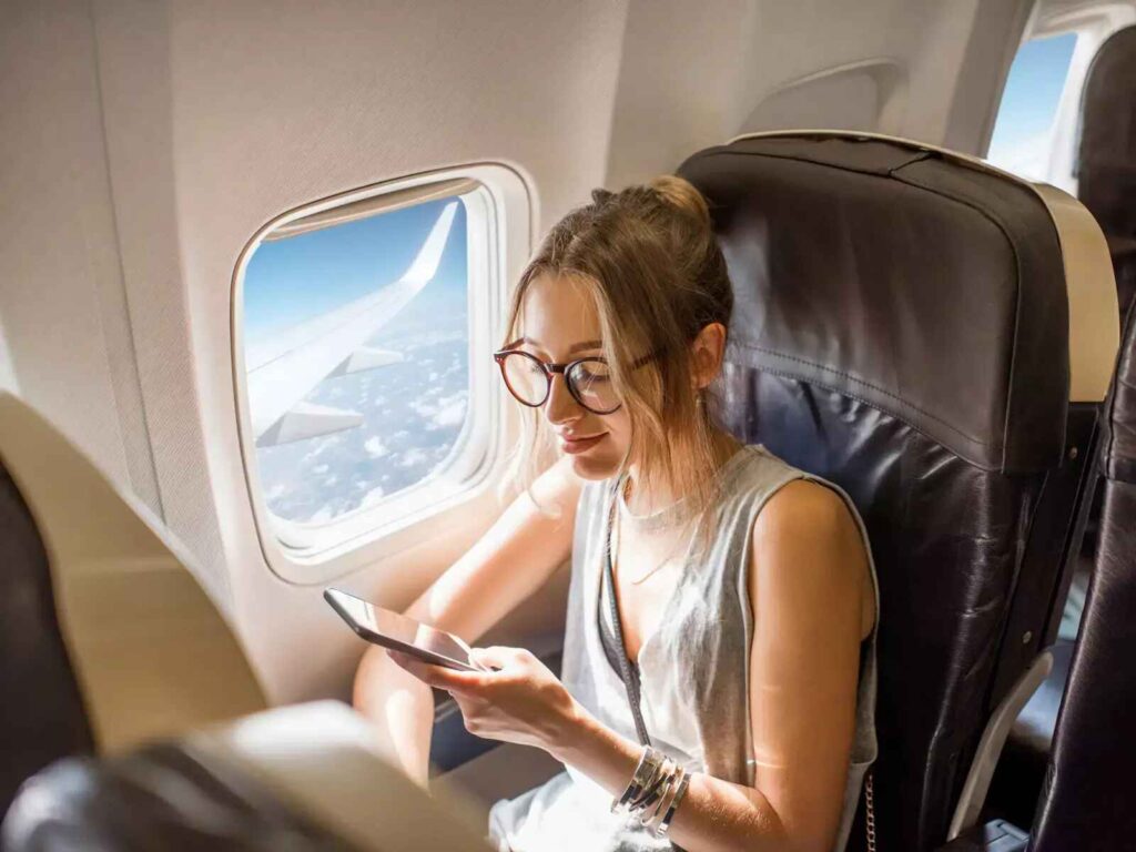 girl with specs with her smartphone in airlines